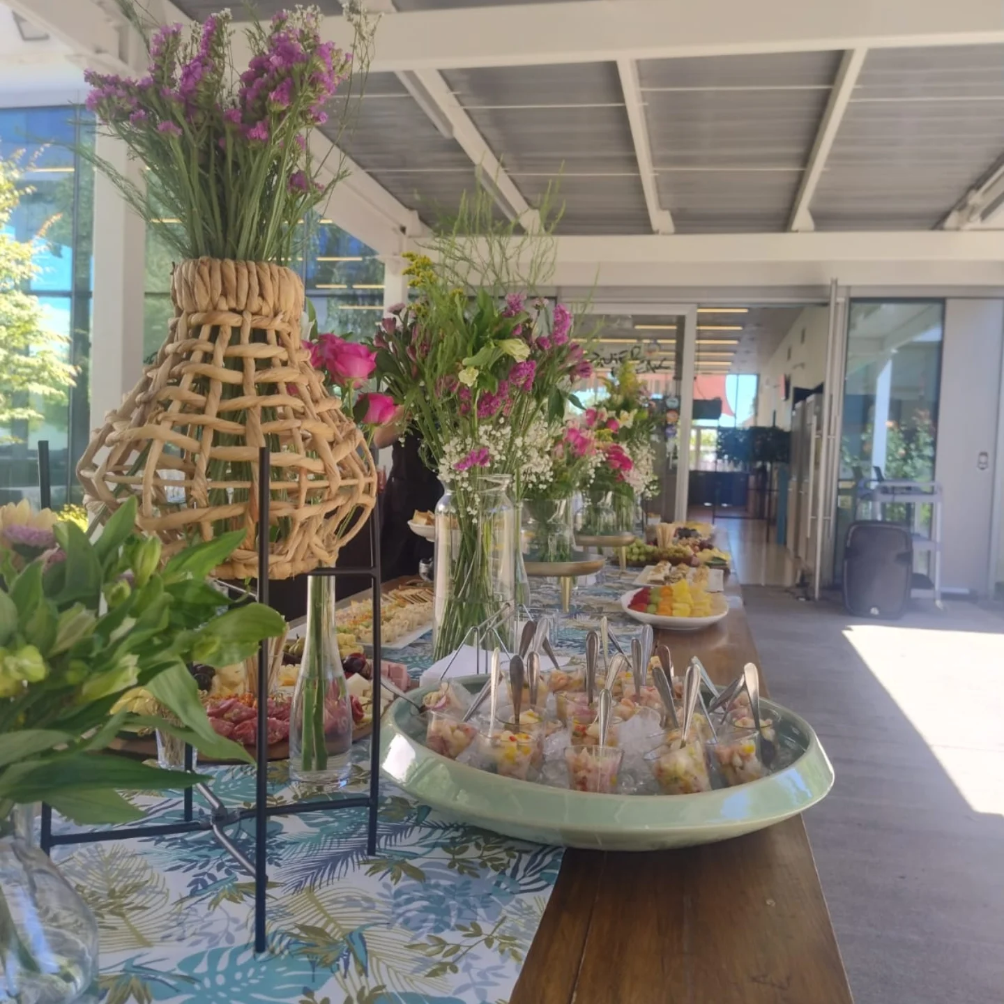 Montaje de mesa buffet con arreglos florales y preparaciones variadas